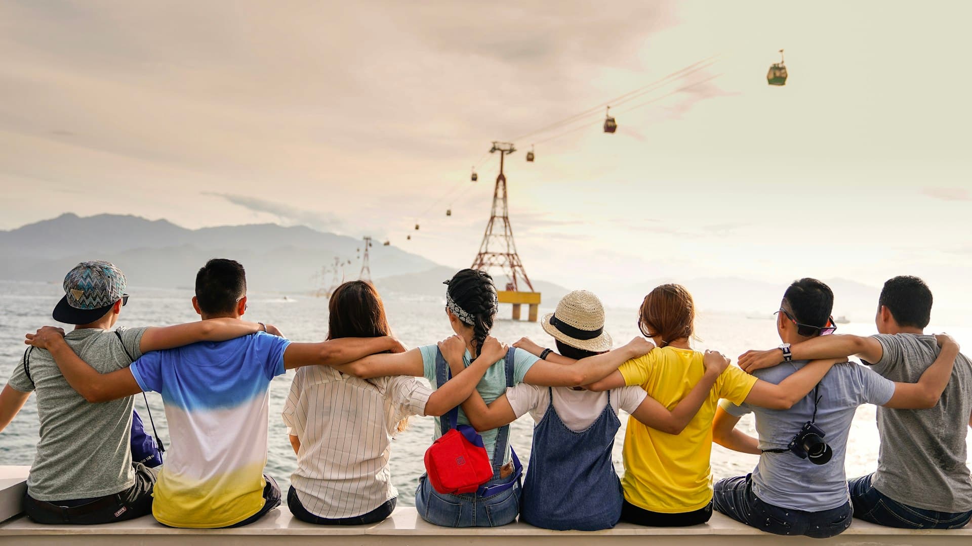 A group of friends with arms around each other looking out together